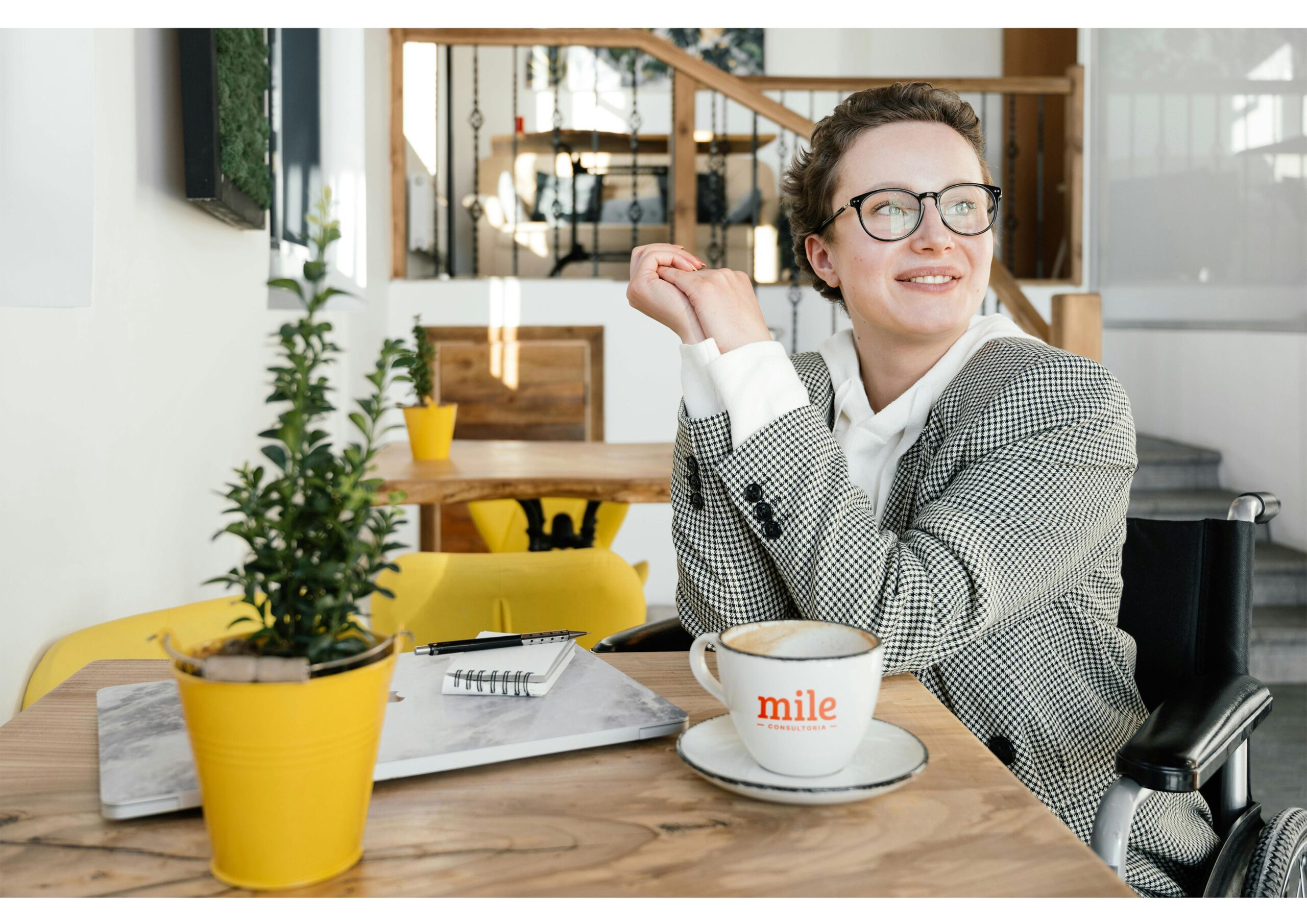 Mulher pensando em carreira sentada diante de uma mesa com café